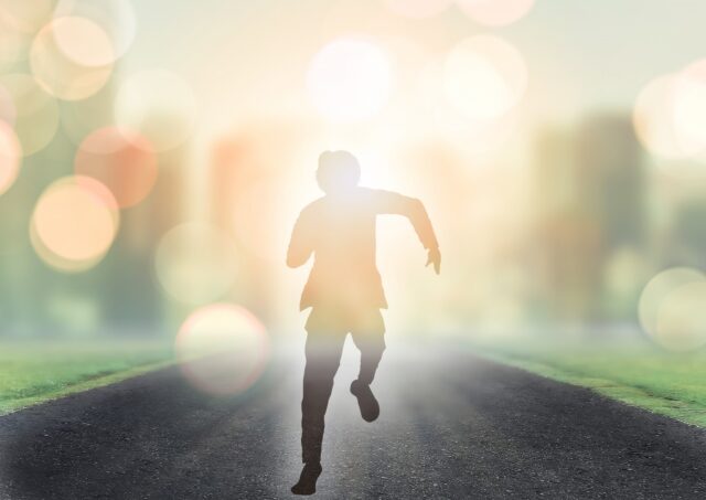 輝く未来へ走る男性シルエット